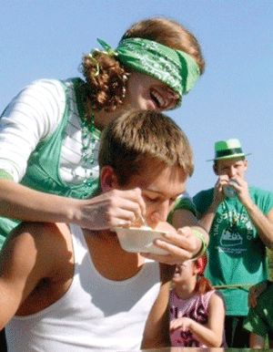 Ice-cream eating contest?  Well, this is a new way to do it.  Blindfold someone and have that person reach around from behind to try to stuff ice cream into your mouth.  Debbie Faught (L) was successful enough feeding Dylan Geske (R) that the two of them won the contest at Webster High Schools homecoming festivities last week. More photos in Currents. - Photo by Aimee Rinnman